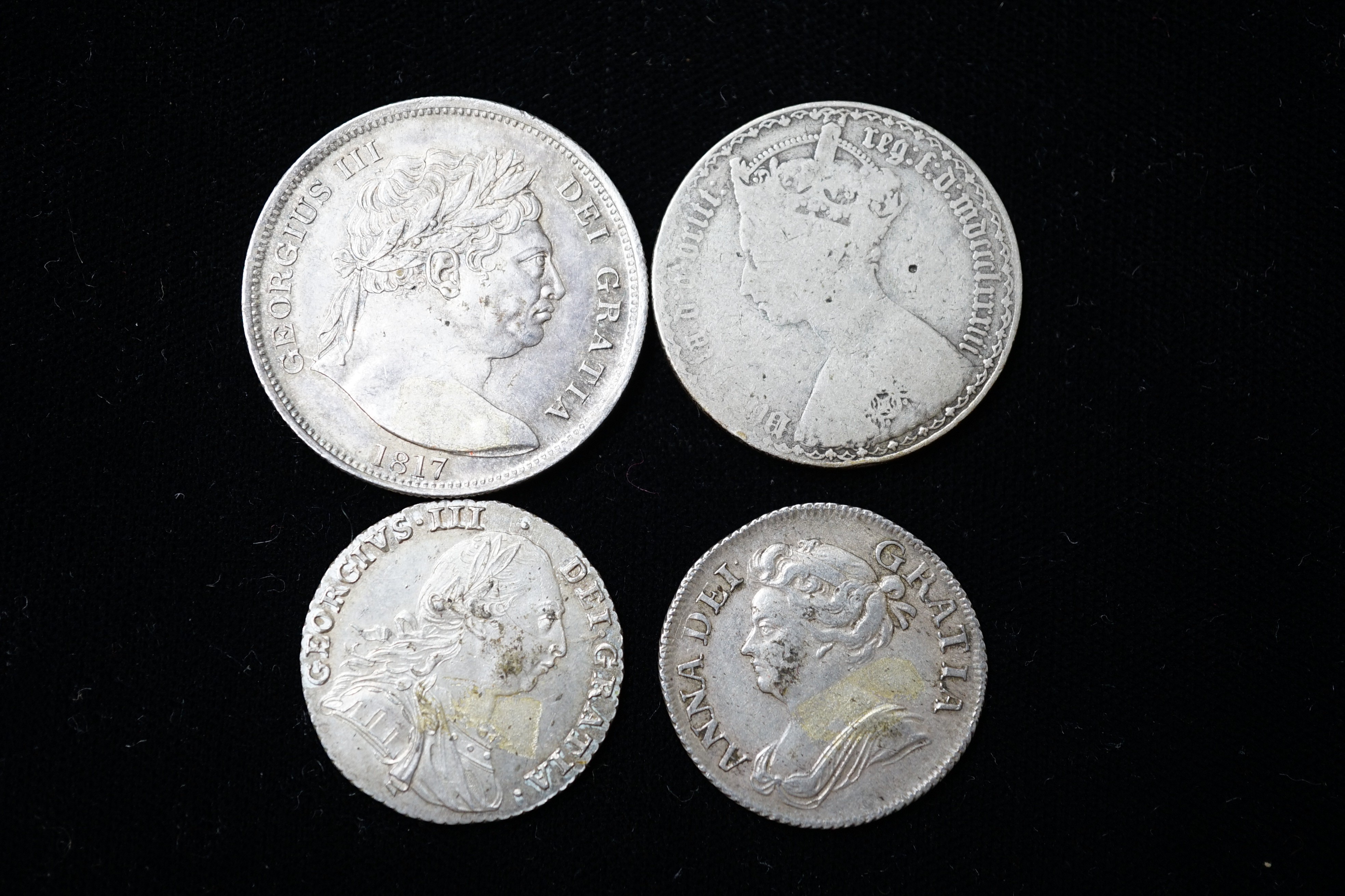 A Queen Anne shilling 1709, about VF, a George III halfcrown, 1817, EF and a George III 1787 shilling, EF and a Victoria Gothic florin